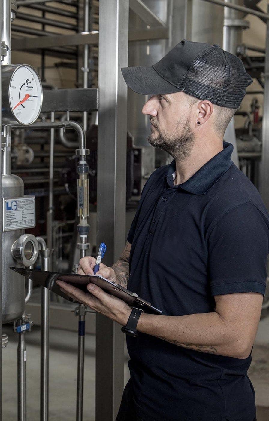 Technician inspecting beverage equipment at BevZero, ensuring quality and precision in production