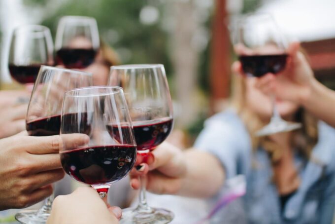 Group of people toasting with glasses of red wine