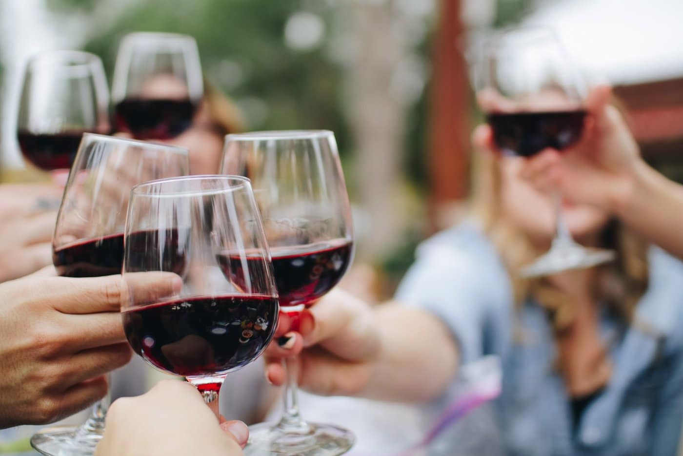 Group of people toasting with glasses of red wine