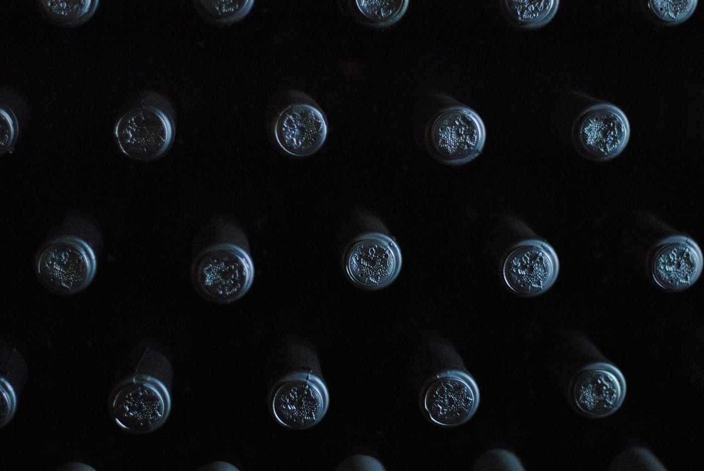 The tops of private label wine bottles with black lids