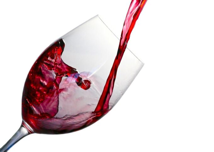 red wine being poured into a clear glass