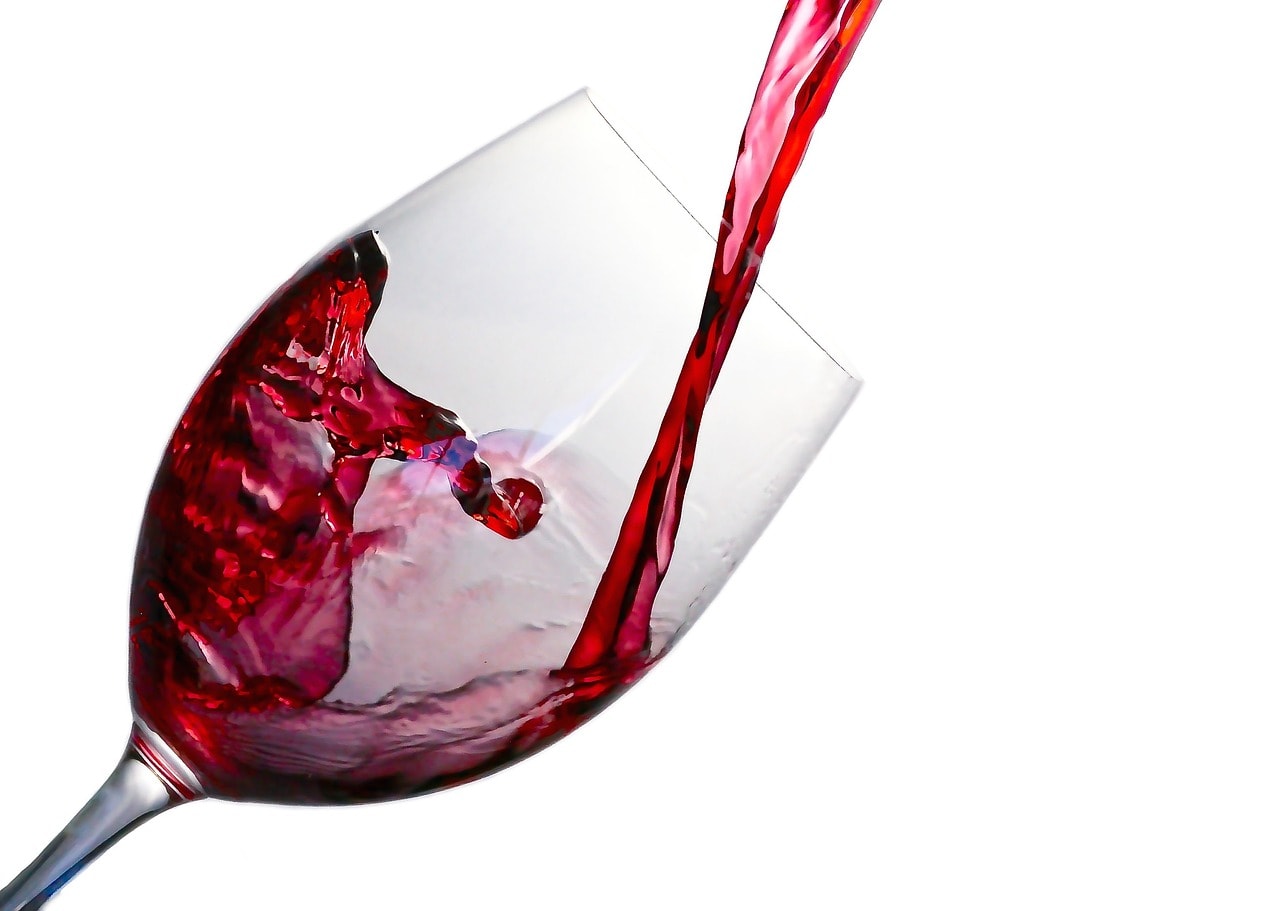 red wine being poured into a clear glass