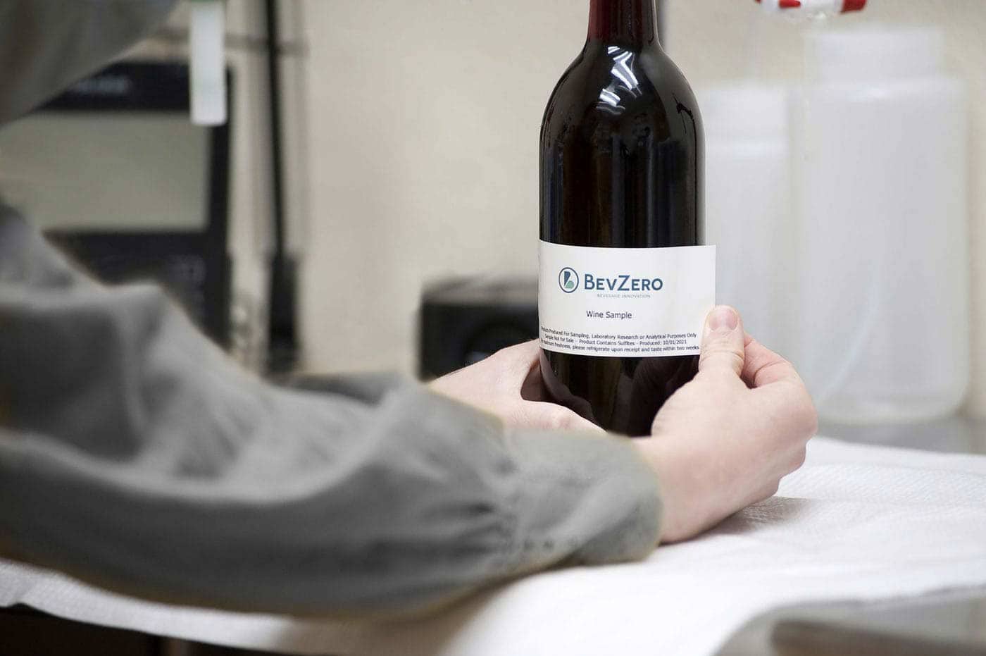 Label being applied to a wine bottle for beverage branding and formulation.