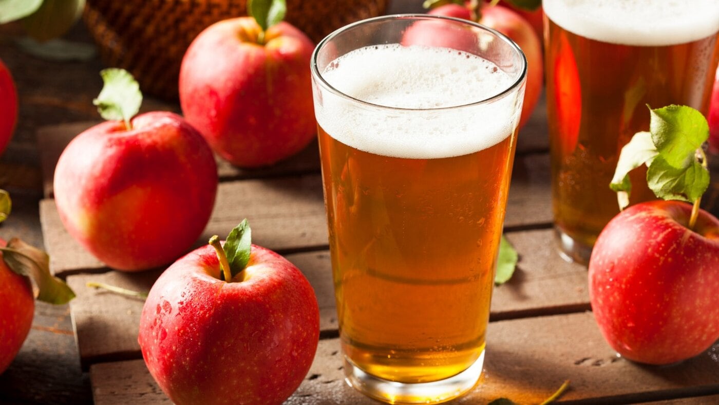 Glass pint of non-alcoholic cider with fresh apples, highlighting alcohol-free drinks.